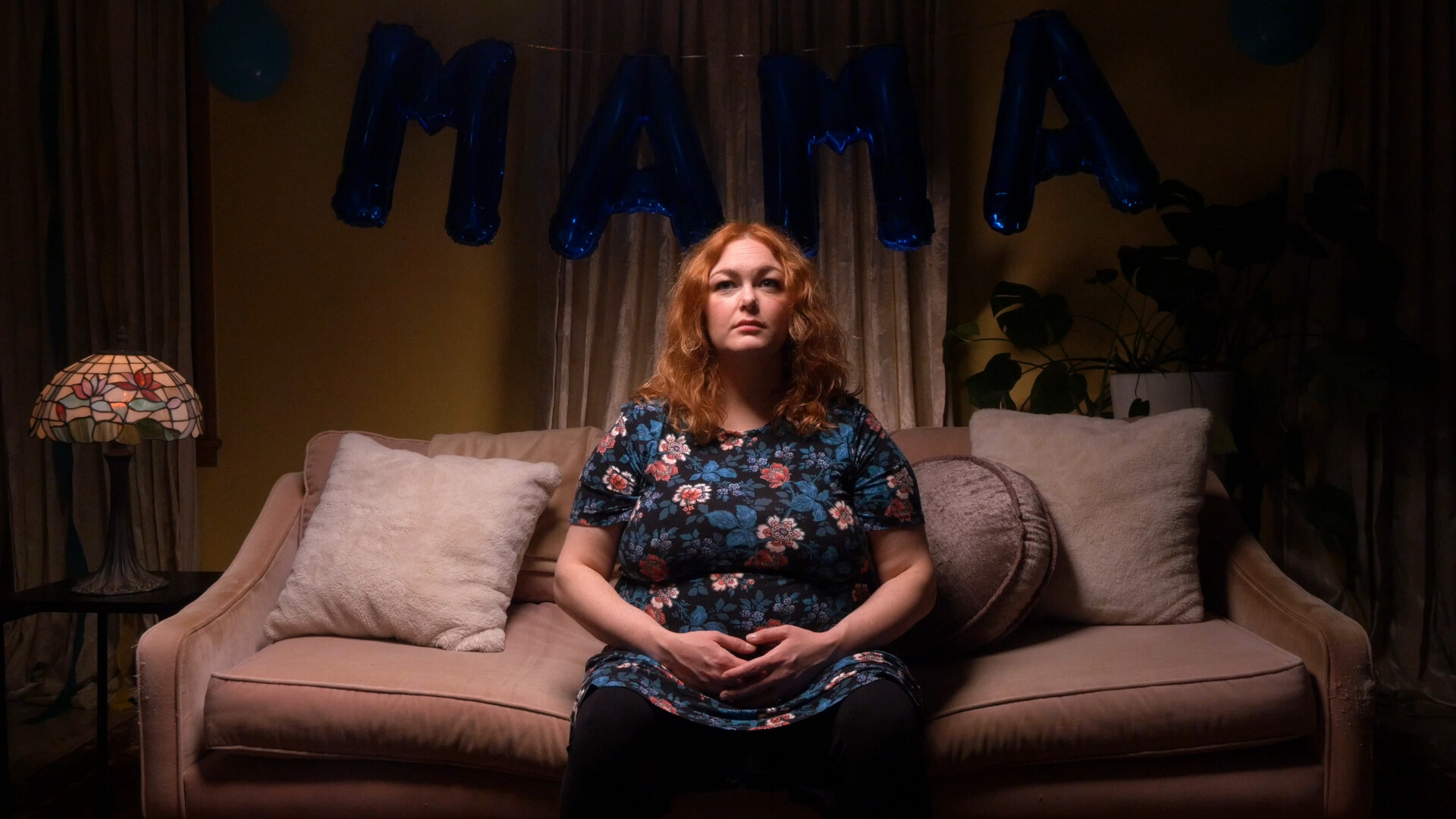 A white woman sits alone on a couch